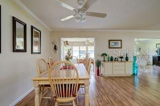 dining area featuring crown molding, hardwood / wood-style floors, and ceiling fan