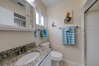 2609 Riverbluff Pkwy Unit 146, Sarasota, FL 34231 - full bath featuring a stall shower, toilet, vanity, and baseboards