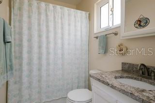 2609 Riverbluff Pkwy Unit 146, Sarasota, FL 34231 - bathroom with vanity, toilet, and a shower with shower curtain