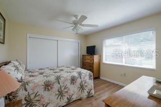 bedroom featuring light hardwood / wood-style floors, a closet, and ceiling fan