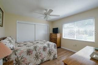 2609 Riverbluff Pkwy Unit 146, Sarasota, FL 34231 - bedroom with wood finished floors, a closet, baseboards, and ceiling fan