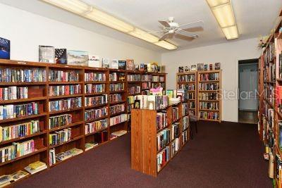 2609 Riverbluff Pkwy Unit 146, Sarasota, FL 34231 - sitting room with bookshelves, ceiling fan, and carpet