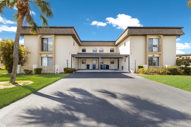 view of front of house with a front lawn and a balcony