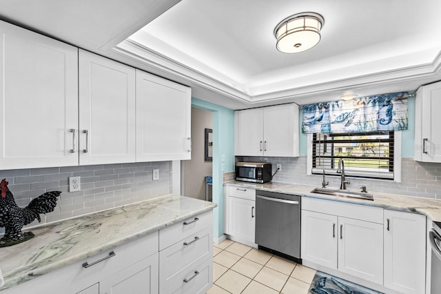 kitchen with white cabinetry, appliances with stainless steel finishes, sink, and a raised ceiling