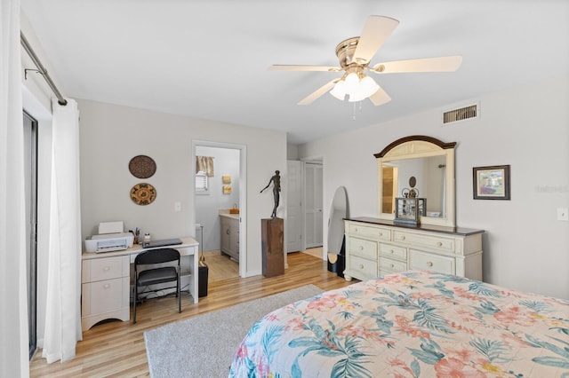 bedroom featuring ceiling fan, ensuite bath, and light wood-type flooring