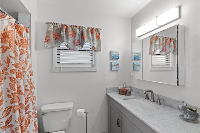 bathroom with a shower with shower curtain, vanity, and toilet