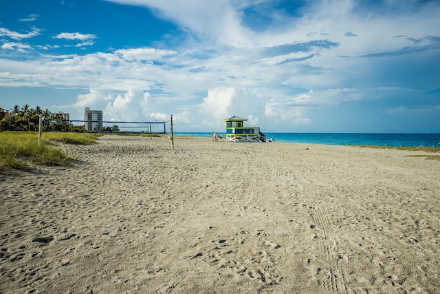 view of home's community with a view of the beach, volleyball court, and a water view