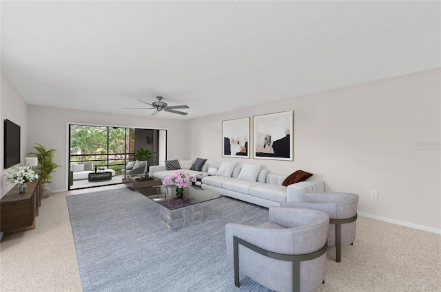 living area featuring light colored carpet, a ceiling fan, and baseboards