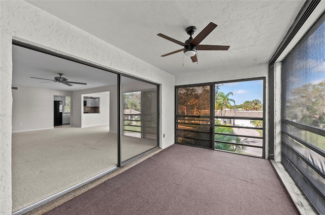 unfurnished sunroom featuring a ceiling fan