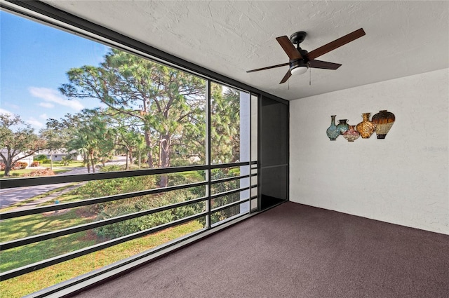 unfurnished sunroom featuring ceiling fan