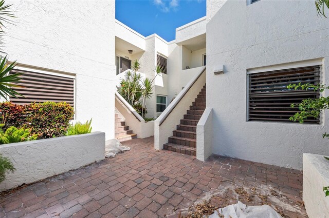 entrance to property with a patio and stucco siding