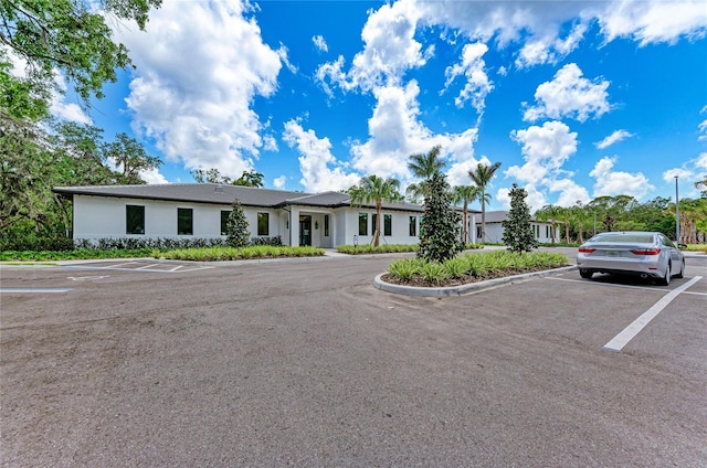 view of front of house featuring stucco siding and uncovered parking