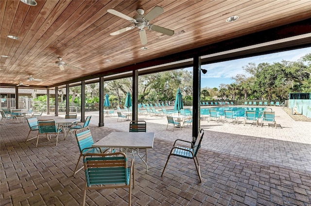 view of patio / terrace with outdoor dining area, a community pool, and fence