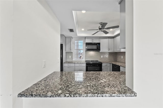 kitchen with visible vents, backsplash, ornamental molding, black appliances, and a raised ceiling