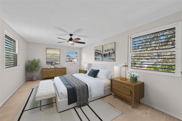 bedroom featuring light colored carpet, baseboards, and ceiling fan