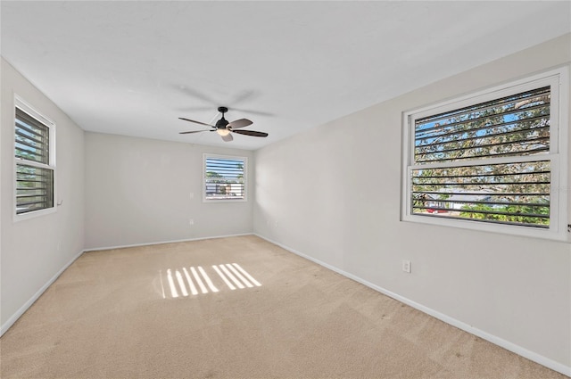 spare room with ceiling fan, baseboards, and carpet