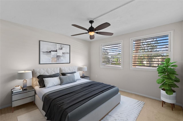 bedroom with baseboards, light colored carpet, and a ceiling fan