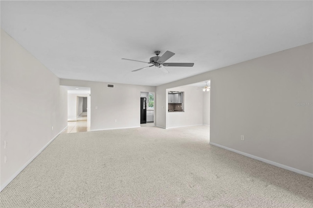 empty room featuring visible vents, baseboards, light colored carpet, and a ceiling fan