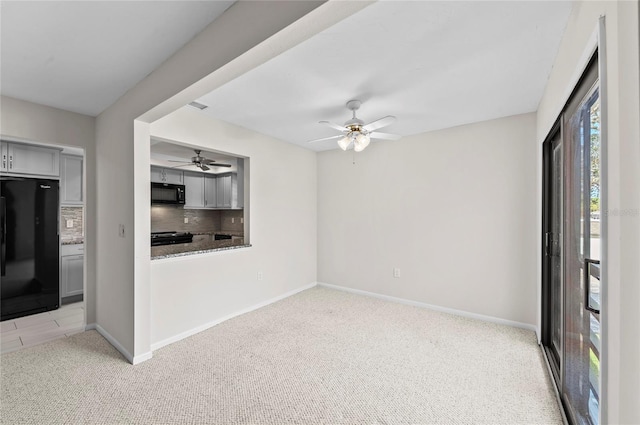 interior space featuring visible vents, baseboards, light colored carpet, and ceiling fan