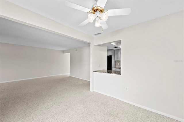 spare room featuring visible vents, baseboards, carpet, and ceiling fan