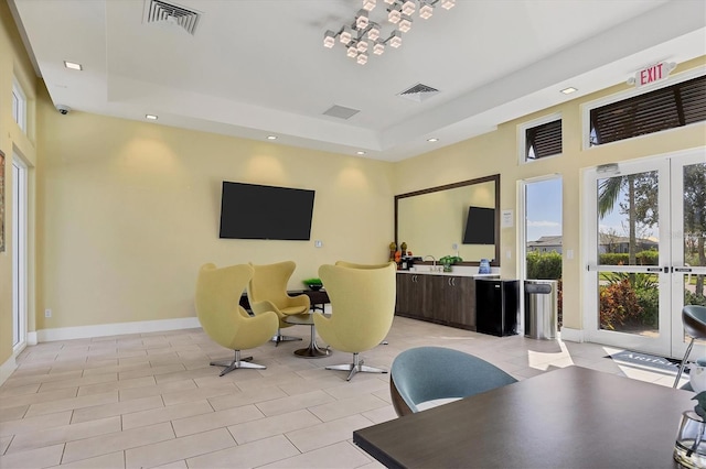 tiled office space with french doors and a tray ceiling