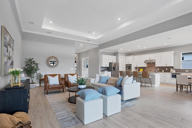 living room with a raised ceiling and crown molding