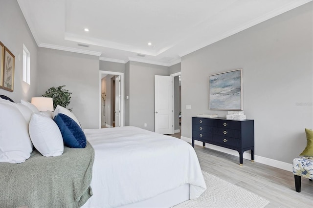 bedroom featuring a raised ceiling, crown molding, and light wood-type flooring