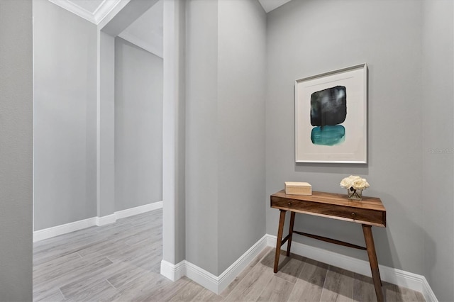 corridor with crown molding and light wood-type flooring