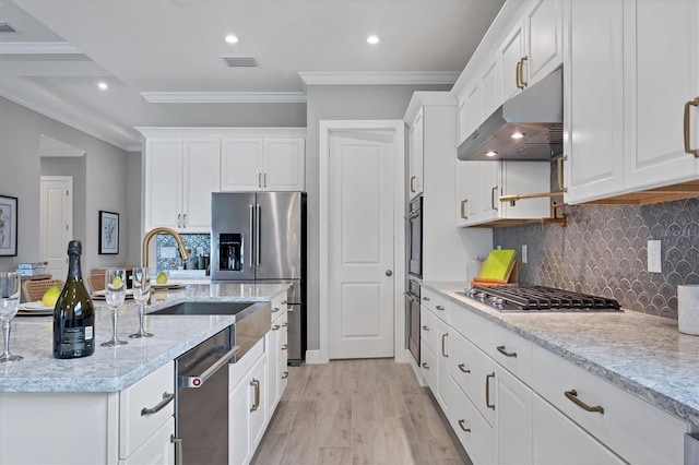 kitchen featuring light stone counters, white cabinetry, tasteful backsplash, appliances with stainless steel finishes, and ornamental molding