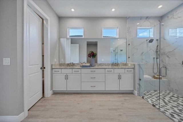 bathroom featuring vanity and a shower with door