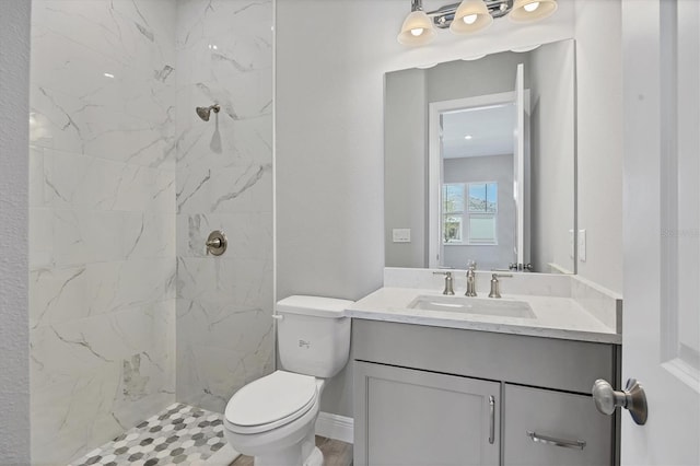 bathroom featuring vanity, toilet, and a tile shower