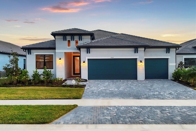 prairie-style house with a garage and a yard