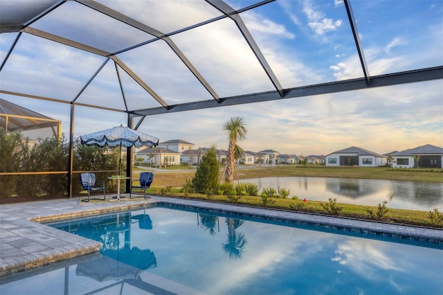 view of pool featuring a lanai, a patio area, and a water view