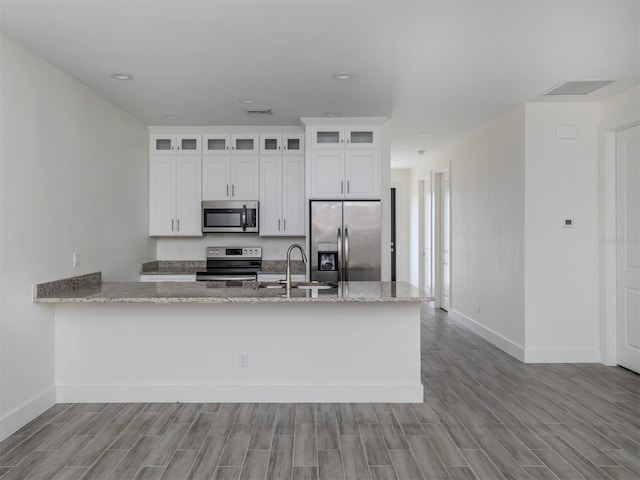 kitchen featuring appliances with stainless steel finishes, white cabinetry, sink, and light wood-type flooring