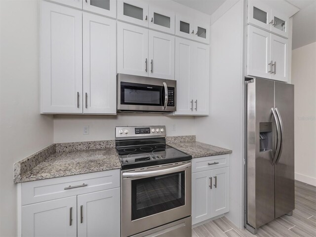 kitchen with white cabinetry, light hardwood / wood-style floors, and stainless steel appliances