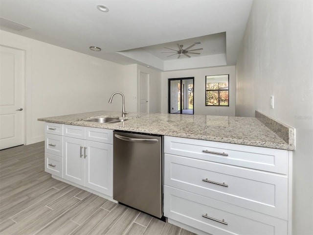 kitchen featuring light hardwood / wood-style flooring, white cabinets, stainless steel dishwasher, and sink