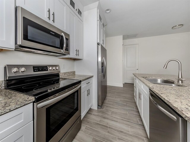 kitchen featuring appliances with stainless steel finishes, sink, and white cabinets