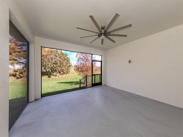 unfurnished sunroom featuring ceiling fan