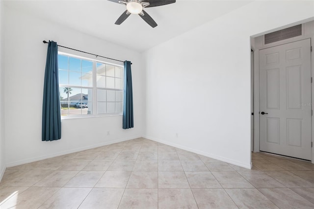 tiled spare room featuring ceiling fan