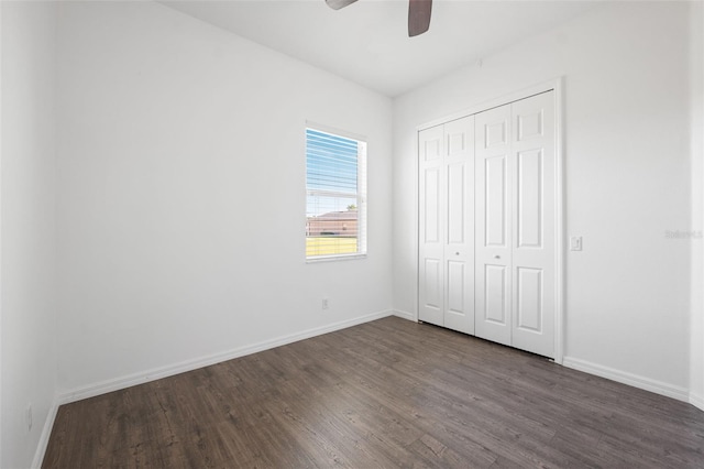 unfurnished bedroom featuring dark hardwood / wood-style floors, a closet, and ceiling fan