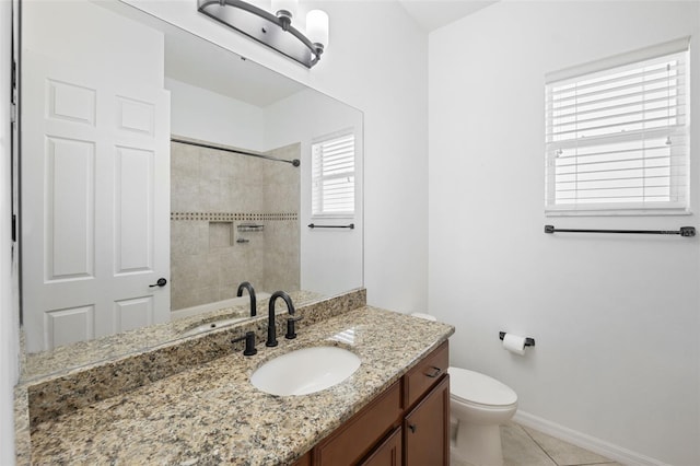 bathroom with toilet, vanity, tiled shower, and tile patterned floors