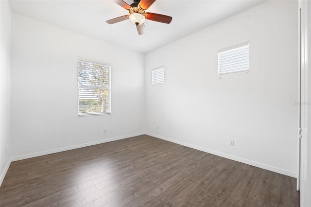 empty room featuring ceiling fan and dark hardwood / wood-style flooring