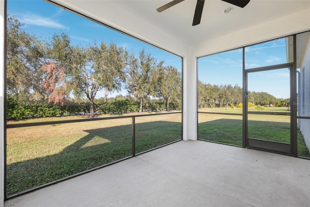 unfurnished sunroom with ceiling fan