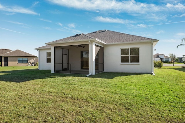 back of house featuring a lawn and a sunroom