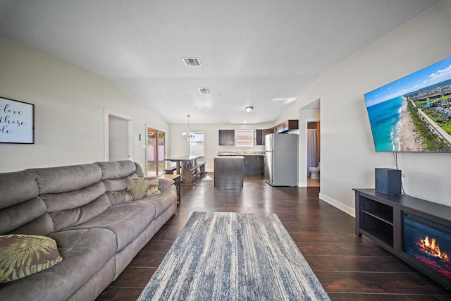 living room featuring sink and lofted ceiling