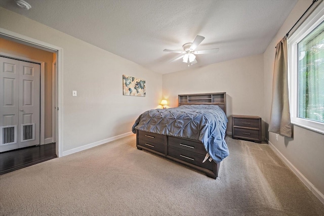 bedroom with a textured ceiling, carpet flooring, and ceiling fan