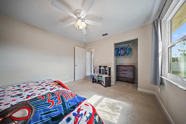 carpeted bedroom featuring ceiling fan and a closet