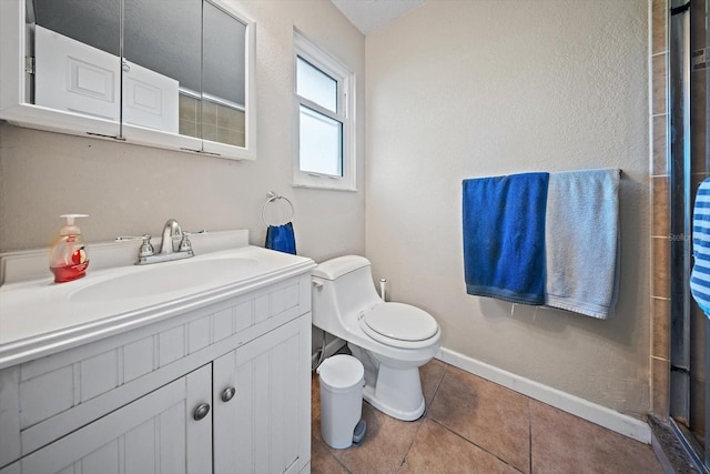 bathroom with vanity, toilet, a shower, and tile patterned floors