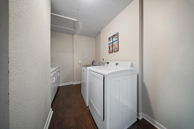 laundry area with cabinets, dark wood-type flooring, a textured ceiling, and washing machine and clothes dryer