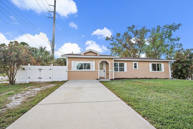 view of front of property with a front lawn, a gate, fence, and stucco siding